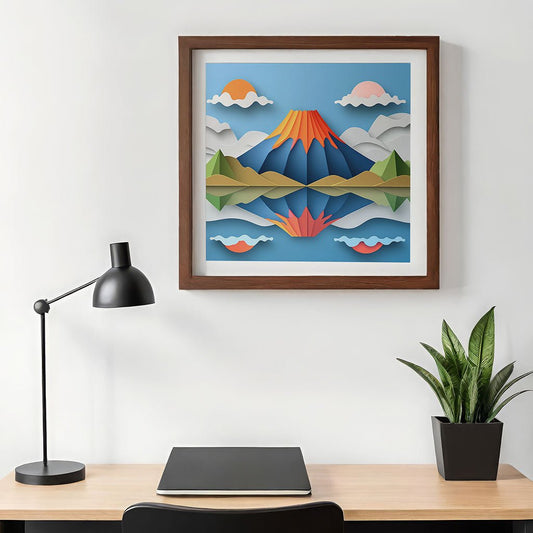 A minimalistic desk setup includes a black lamp, a closed laptop, and a potted plant. Above the desk is "2 Suns Volcano," a colorful, framed landscape artwork by FN Prints, showcasing mountains and clouds in a folded paper effect that evokes stunning digital art.