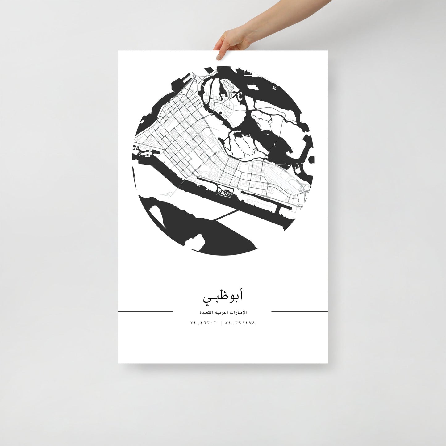 A black and white minimalist print of Abu Dhabi city map, held up against a white background