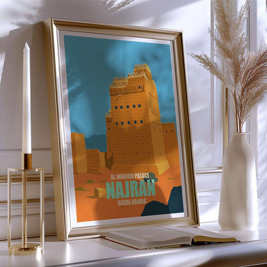 Framed poster of Al Mahran Palace in Najran, Saudi Arabia, on a shelf with decor items.