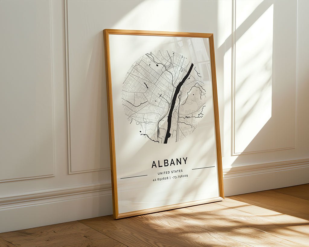 The Albany City Map by FN Prints, made with museum-quality paper, leans against a white paneled wall. The sunlight highlights its minimalistic street layout and geographical coordinates, making it perfect city wall art for any space.