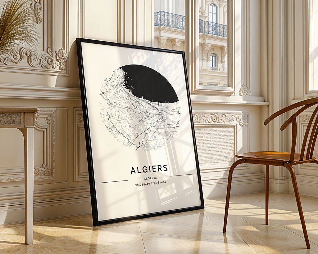 The FN Prints Algiers City Map poster, printed sustainably with a minimalist circular street design, rests against an ornate wall in well-lit room. A wooden chair sits nearby as sunlight streams through the windows.