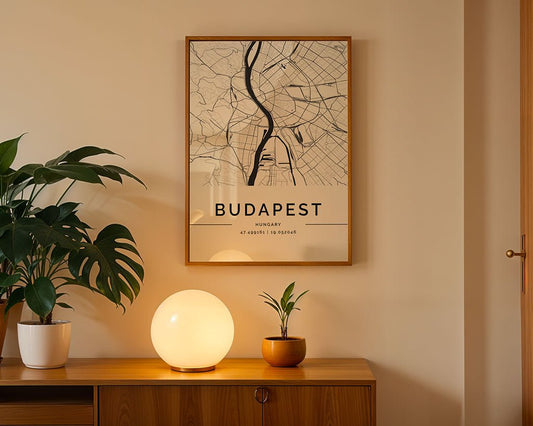 A framed FN Prints Budapest City Map adorns the beige wall above a wooden sideboard, where a spherical lamp and two potted plants enhance the warm, minimalist decor—ideal for architecture lovers.