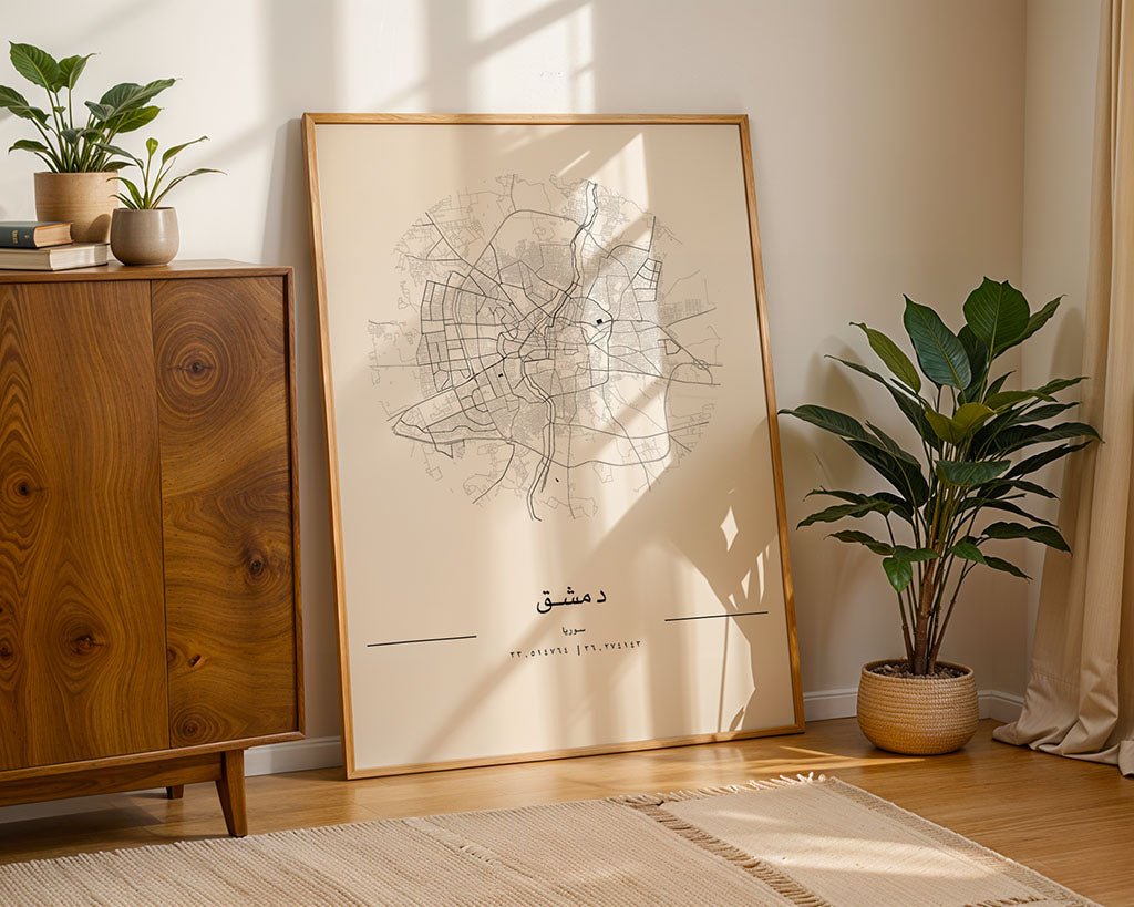 The FN Prints Damascus City Map, a minimalist print with Arabic text on museum-quality fine art paper, is displayed against a wall near a mid-century cabinet and potted plants as sunlight streams in.