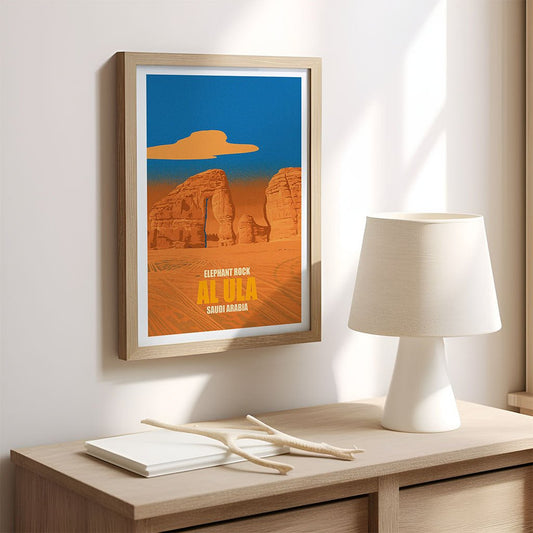 Framed poster of Elephant Rock in Alva, Oklahoma on a wall above a wooden desk with a lamp.