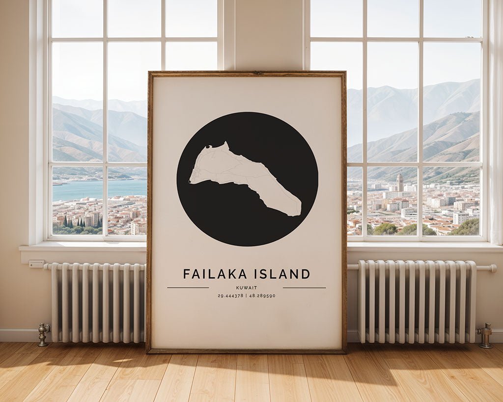 An FN Prints Failaka Island City Map poster, framed and minimalist with the island's silhouette and coordinates inside a black circle, leans against a room wall. Through the large windows, there are views of mountains and a coastal city.