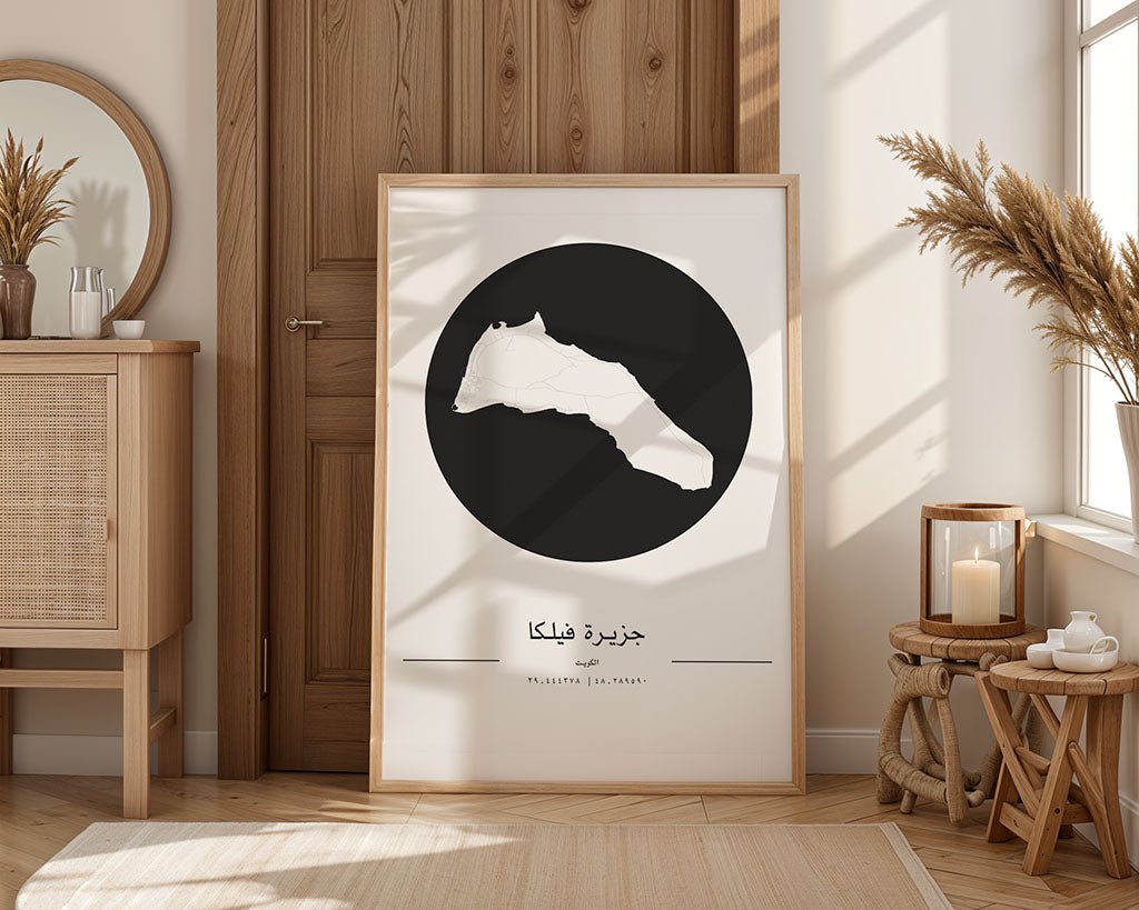 A cozy room features a wooden cabinet, wicker chair, and a large framed map of Libya leaning against the wall. An FN Prints Failaka Island City Map adds charm. The room is decorated with dry plants and bathed in natural light from a nearby window.