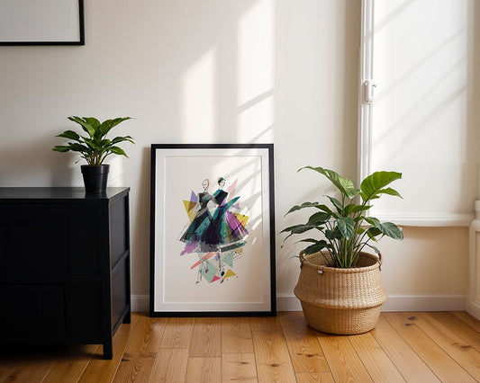 The FN Prints "Fashion Duo Abstract" framed art leans against a wall on a wooden floor, with sunlight streaming in and potted plants nearby atop a black cabinet and in a woven basket.