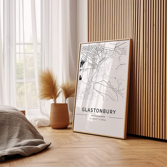 The FN Prints Glastonbury City Map is displayed in a frame against a wooden wall beside a beige basket with dried pampas grass—an ideal minimalist decor piece for any space.