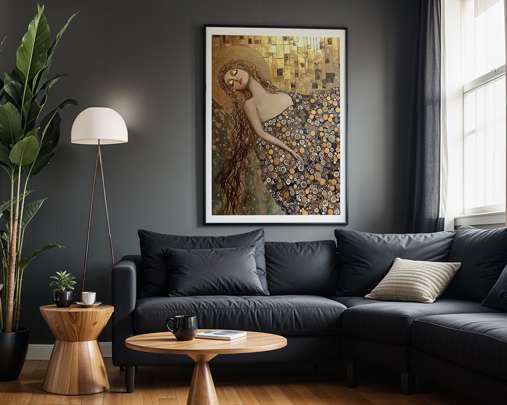 A living room features a dark gray sofa, a wooden coffee table, and a floor lamp. The wall is adorned with "Golden Dreamscape," a framed digital artwork by FN Prints in the style of Gustav Klimt depicting a woman in a patterned dress. In the corner stands a potted plant, while light streams through a window with dark curtains.