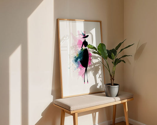 FN Prints’ Haute Silhouette, a framed fashion wall art of a stylized woman in a dress, leans on a wooden bench beside a potted plant. Sunlight and shadows enhance the modern vibe of this minimally decorated corner.