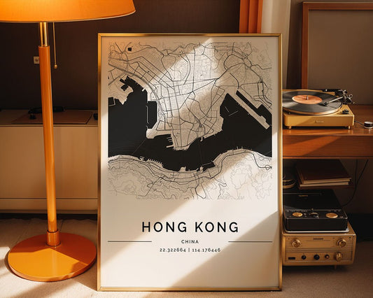 A framed Hong Kong City Map by FN Prints is placed beside a vintage record player and tall orange lamp. This minimalist decor piece showcases detailed street layouts with geographic coordinates elegantly displayed at the bottom.