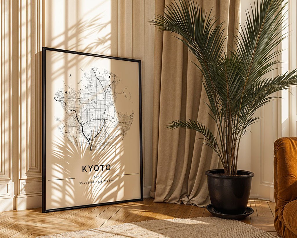 An FN Prints Kyoto City Map rests against a wall by a large potted palm. Sunlight filters through the leaves, casting shadows on the fine art paper and wooden floor. Beige curtains hang to the right, with an orange sofa corner peeking into view.