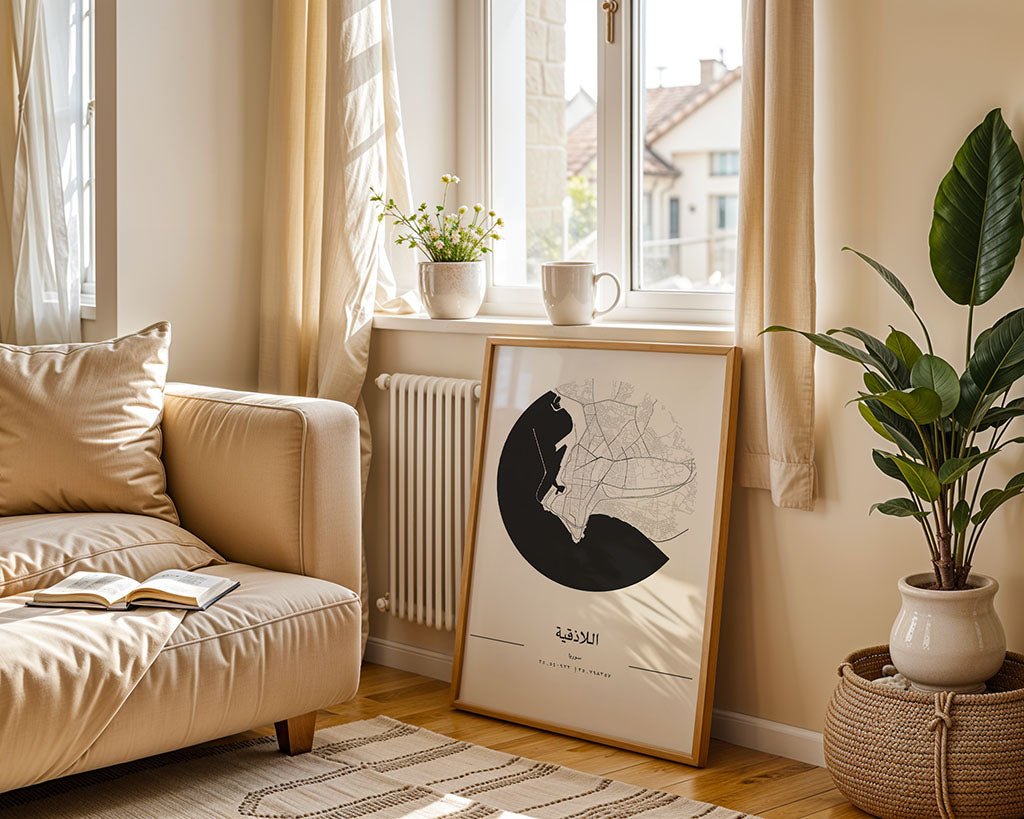 A cozy living room features a beige sofa and an open book, with light curtains framing the windows. A minimalist FN Prints Latakia City Map rests on the floor beside green plants. Soft sunlight brightens the space, highlighting its warm, neutral decor.
