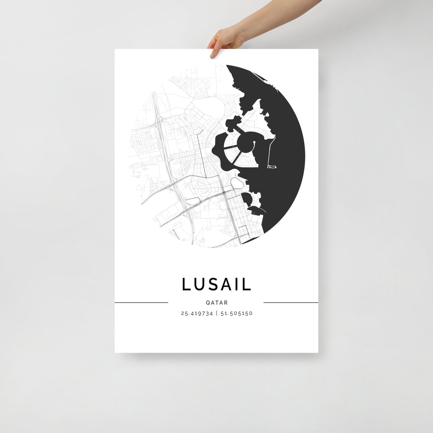 A black and white minimalist map poster of Lusail City, Qatar, held by a hand against a white background.