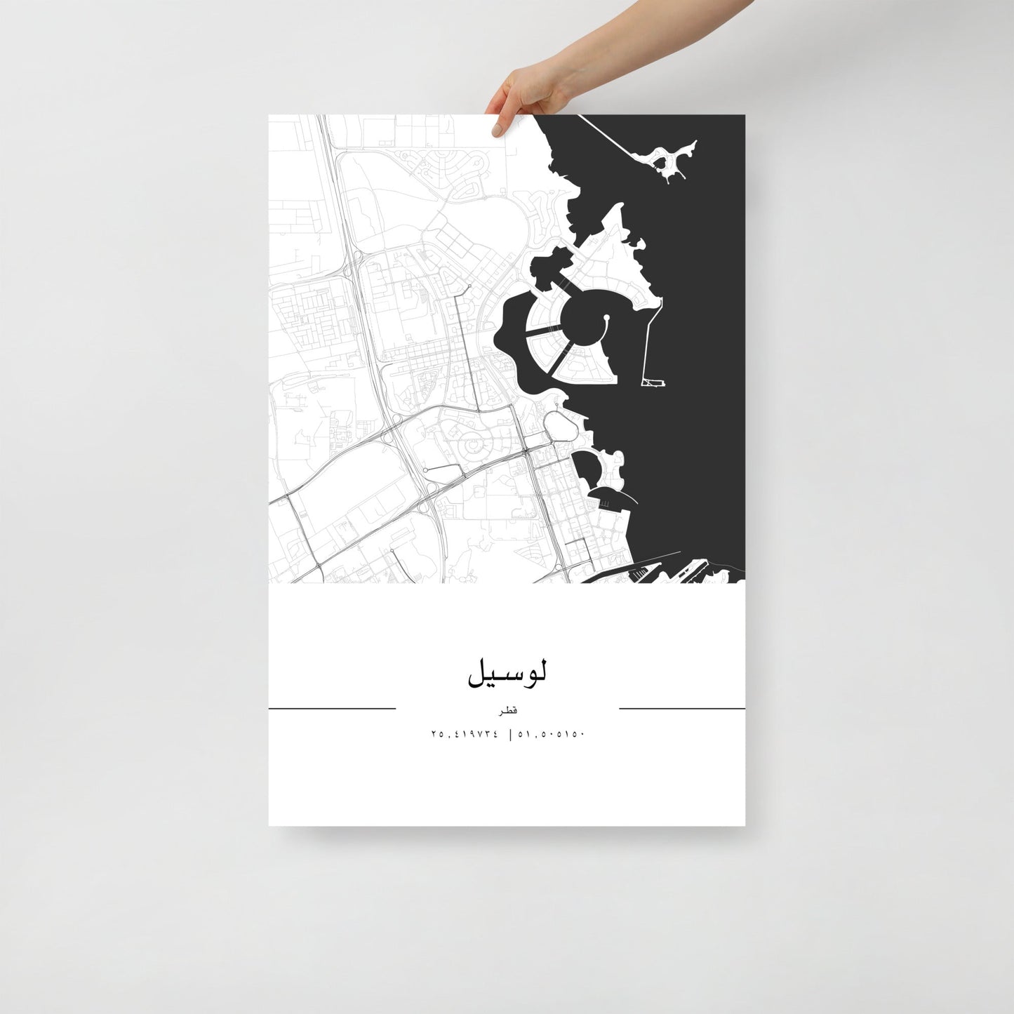 A black and white minimalist map poster of Lusail City, Qatar, held by a hand against a white background.