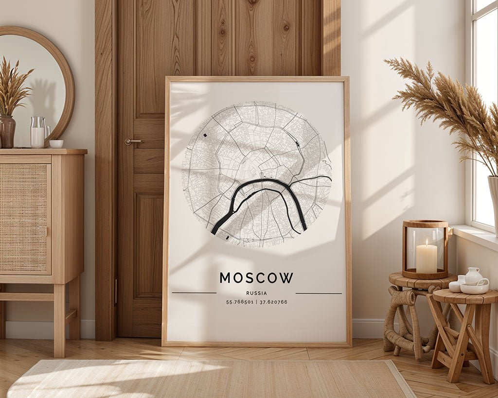A FN Prints black and white Moscow City Map poster adds an urban design vibe as it leans against a wooden door. Nearby, a cabinet holds a round mirror. Sunlight streams through the window, illuminating dried plants in a vase and candles, creating a serene ambiance.