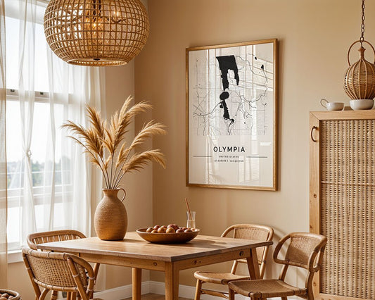 A cozy dining room showcases a wooden table, wicker chairs, a large pendant lamp, and a vase with pampas grass. The wall is adorned with FN Prints' "Olympia City Map." Natural light filters through sheer curtains covering two windows.