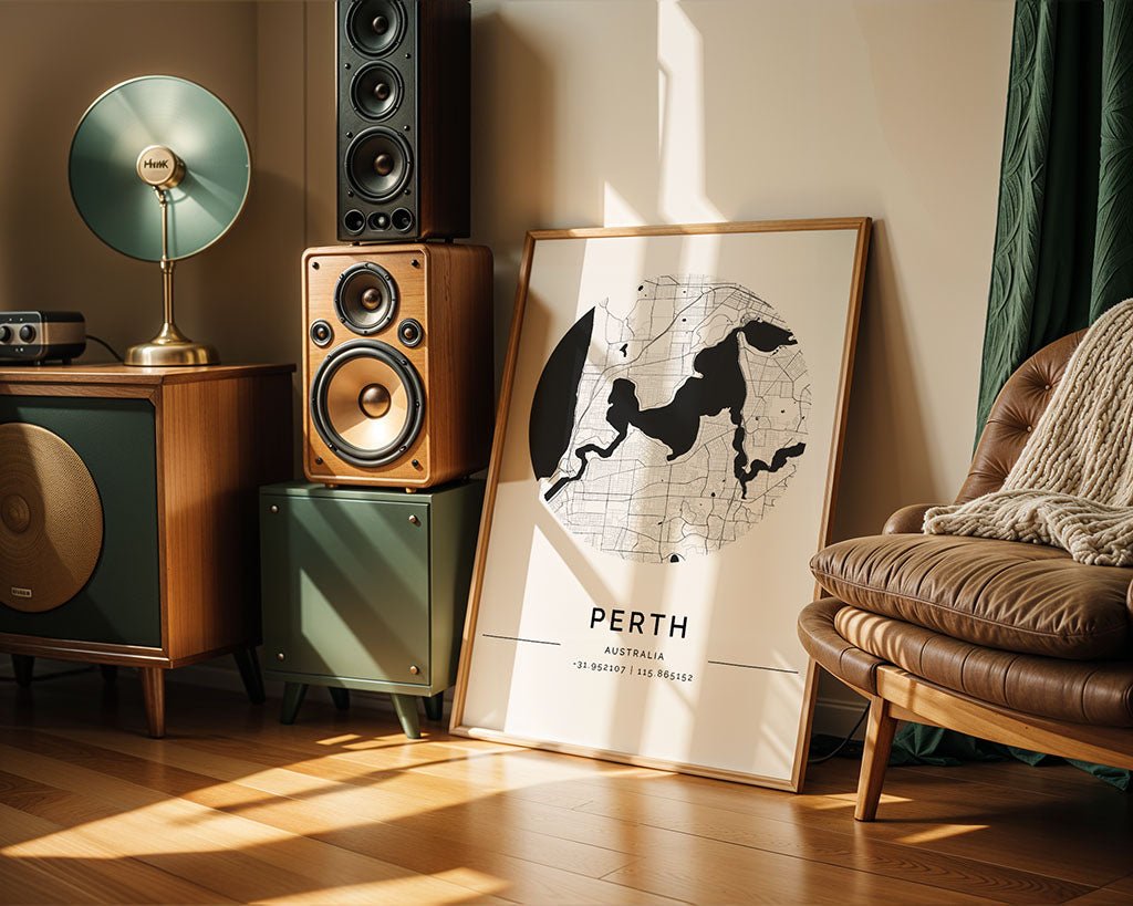 A cozy living room corner features modern interiors with a vintage-style speaker system, an elegant floor lamp, and a minimalist Perth City Map by FN Prints. A leather chair with a knitted blanket rests on wooden flooring as sunlight streams in.