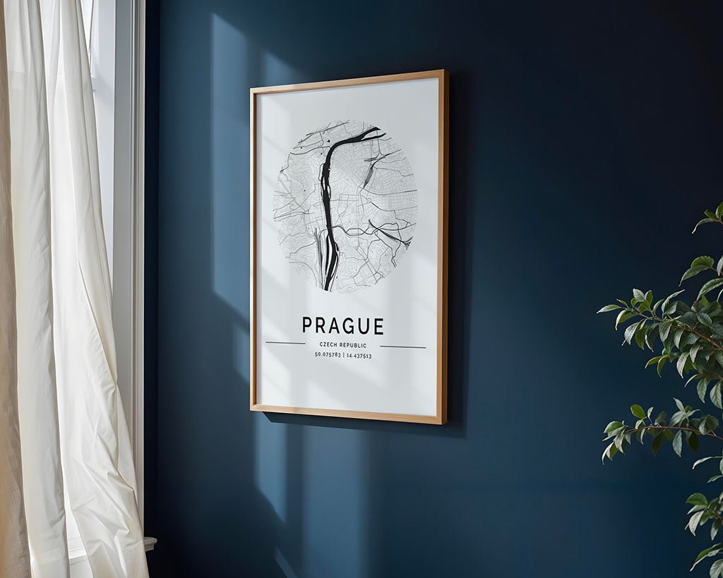 A stunning FN Prints Prague City Map graces the dark blue wall with sunlight streaming through a nearby window. Partially visible are a curtain and plant that enhance the ambiance, while the print showcases detailed street lines with "Prague" prominently displayed, making it exquisite wall art.