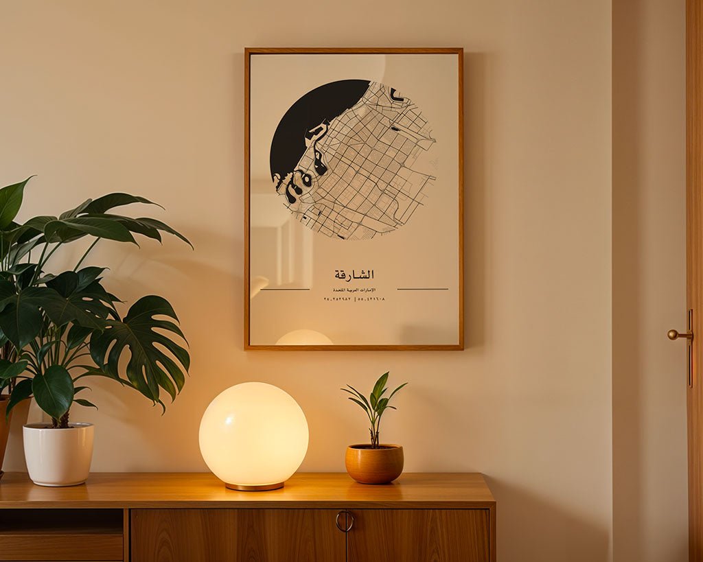 A wooden sideboard with a glowing round lamp, two potted plants, and the FN Prints Sharjah City Map featuring Arabic text displayed on a beige wall.