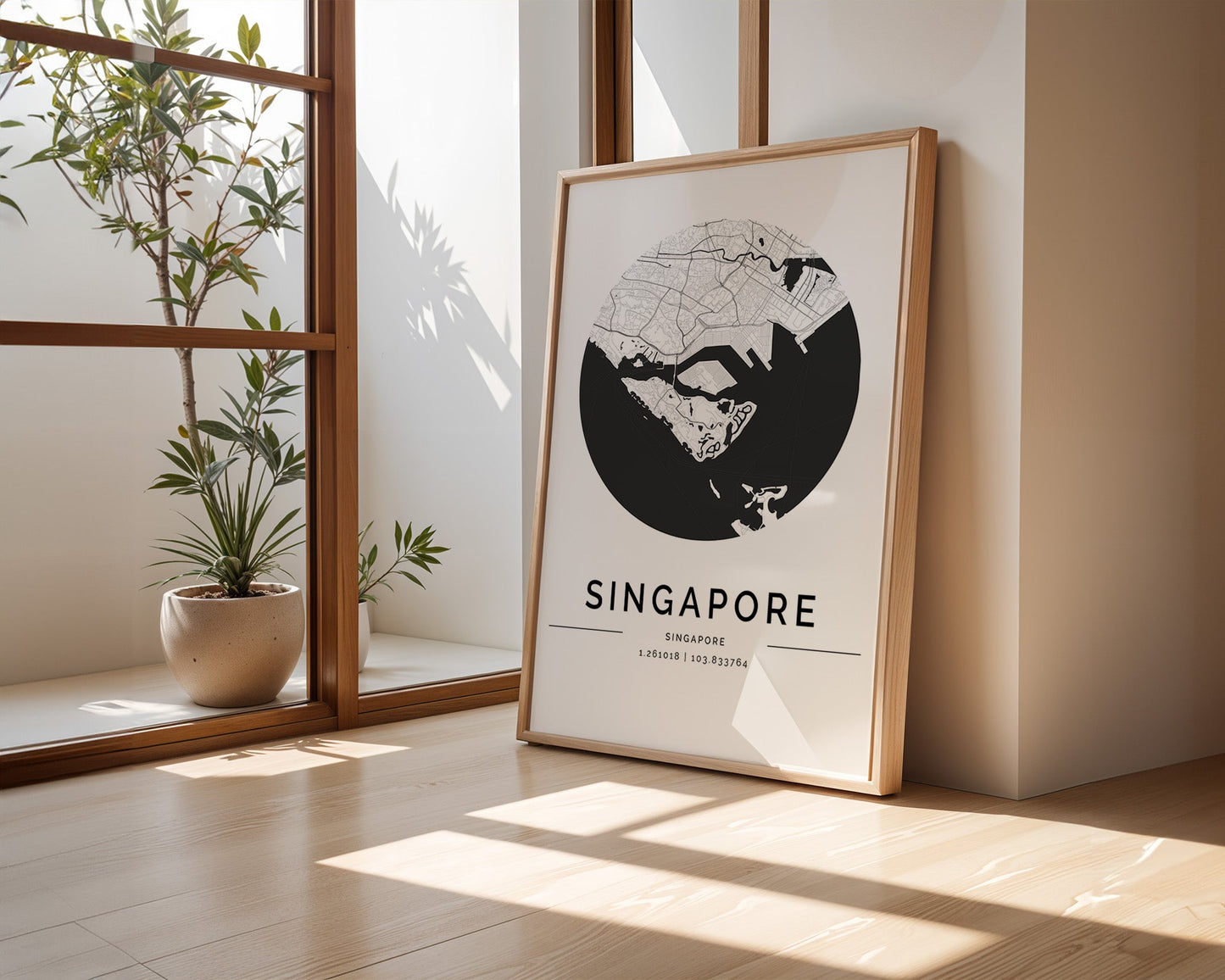 In a minimalist room with wooden flooring and large windows, a FN Prints Singapore City Map rests against the wall. Nearby, a potted plant brings in a hint of greenery, as sunlight gracefully paints shadows on the floor.
