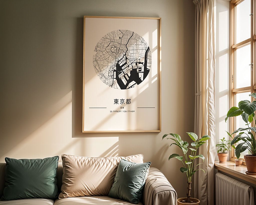 A bright living room with a beige sofa, green and gray pillows, and potted plants is accented by the FN Prints Tokyo City Map above the sofa. Sunlight streams in, highlighting the minimalist Japanese wall art.