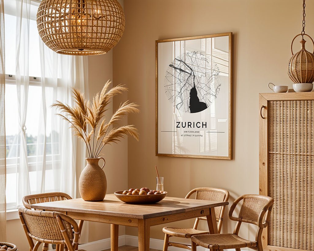 A cozy dining area has a wooden table and chairs under a wicker pendant light. A Zurich City Map by FN Prints highlights the decor. A vase with dried plants, a tray of apples, and a single glass with a straw on the table add charm.