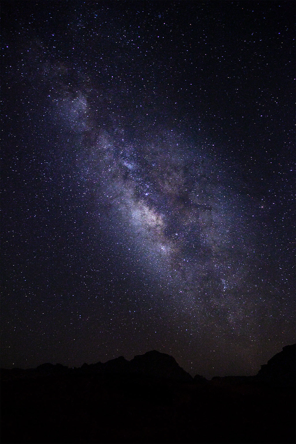 A brilliant, star-filled night sky showcases "The Milky Way" by FN Prints, with the dark, silhouetted Wadi Rum mountains at the bottom. The galaxy's dense cluster of stars forms a bright, hazy band stretching diagonally across the image.