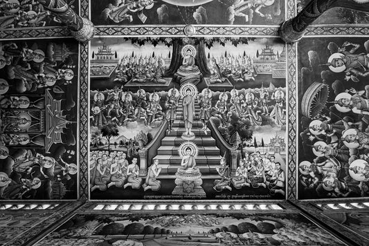 The Sacred Ceiling by FN Prints features a large, intricate mural that covers the ceiling, depicting numerous figures in a historical or religious scene. The central figure appears enlightened, surrounded by followers in a detailed artistic style reminiscent of the elaborate beauty found in Cambodian temple architecture. The monochromatic color scheme enhances the elaborate details and patterns.