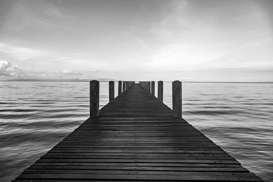 A black and white photograph of a jetty going out to sea