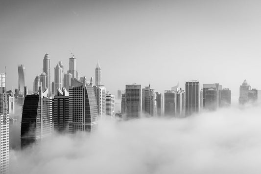 Jumeirah Lake Towers in the morning with fog covering the area and the towers peaking above the clouds. 