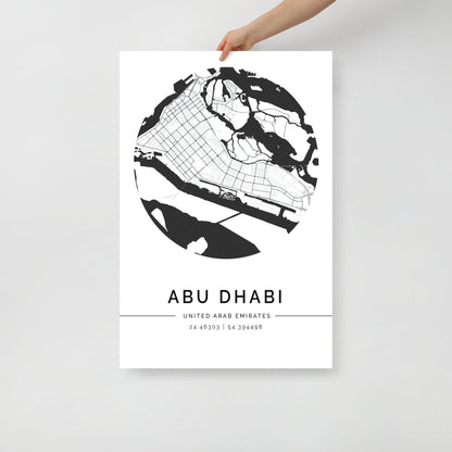 A black and white minimalist print of Abu Dhabi city map, held up against a white background