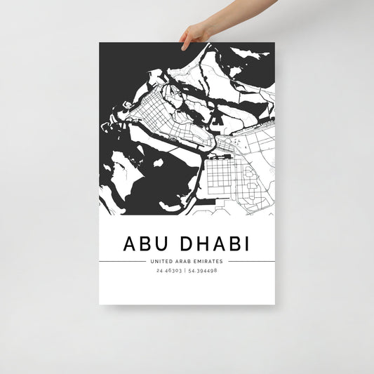 An individual holds an eye-catching black and white City Map Poster of Abu Dhabi, created by FN Prints. This poster showcases intricate outlines of land and water, with the coordinates 24.45303 N, 54.394498 E printed at the bottom, making this Abu Dhabi Map a distinctive addition to any space.