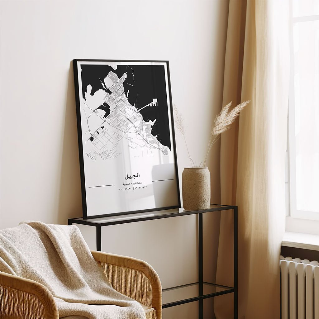 The FN Prints Al Jubail City Map framed print sits on a metal console beside a beige vase with dried grass, a light chair draped with a blanket, and cream curtains, creating a calm, minimalist atmosphere.