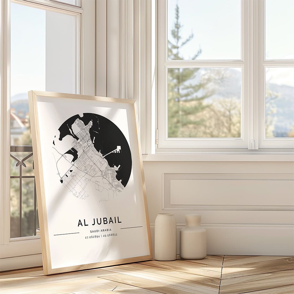The FN Prints "Al Jubail City Map" minimalist framed print rests against a wall by a sunny window, with two decorative vases beside it on the wooden floor.