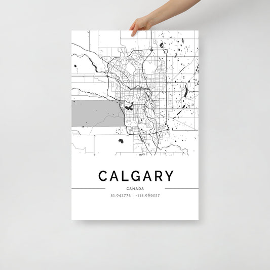 A hand holds an FN Prints Calgary City Map poster, crafted on premium-quality paper. This black and white depiction showcases the urban design, detailing streets and major areas with coordinates 51.043775, -114.069227 elegantly displayed below the city name.