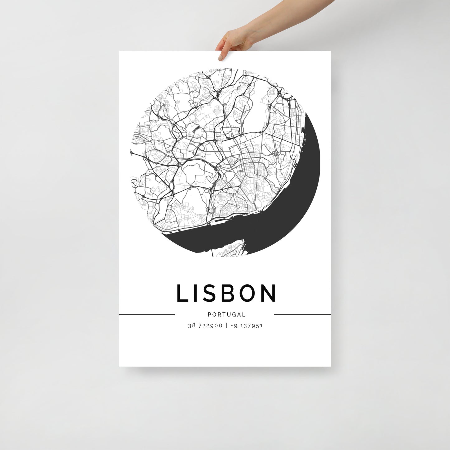 An individual showcases a captivating FN Prints' Lisbon Map, an exquisite black-and-white poster ideal for wall art. The map is meticulously detailed, featuring roads and geographic highlights, with the coordinates 38.722900, -9.137951 elegantly displayed at the bottom.