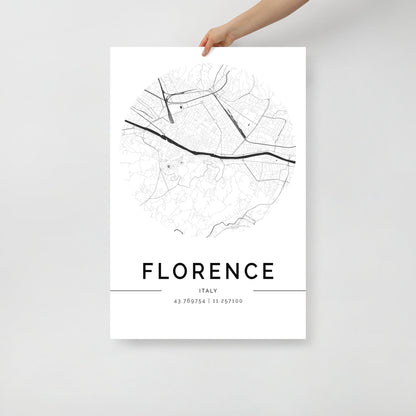 A person holds a minimalist FN Prints Florence Map poster, featuring a circular design with streets and geographic lines. This black-and-white wall art captures the essence of Italian culture, elegantly displaying coordinates at the bottom.