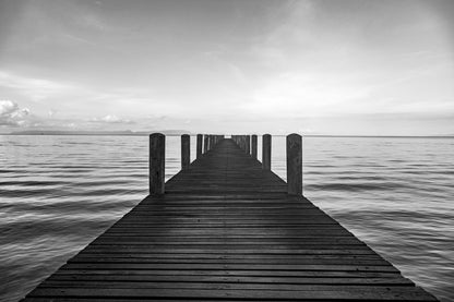 A black and white photograph of a jetty going out to sea