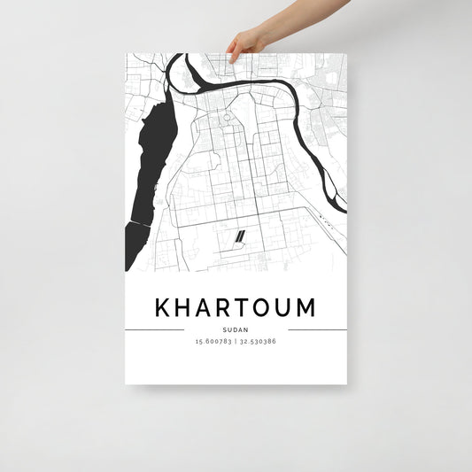 A person holds a striking FN Prints Wall Art Print featuring a black and white street map of Khartoum, Sudan. This compelling piece of Khartoum City Map art includes precise coordinates at the bottom: 15.600783 | 32.530386, capturing the essence of one of the vibrant African cities.