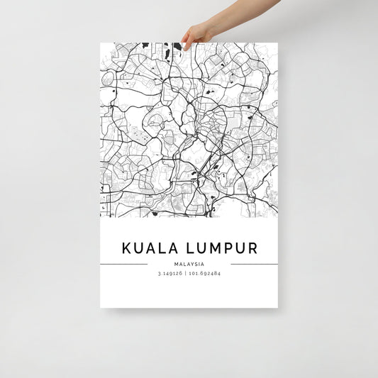 A person holds a Kuala Lumpur City Map by FN Prints, depicting the city's intricate urban design in black and white. The map features "Kuala Lumpur, Malaysia" along with the coordinates "3.14926° | 101.69284°," enhancing its appeal as a piece of wall art.