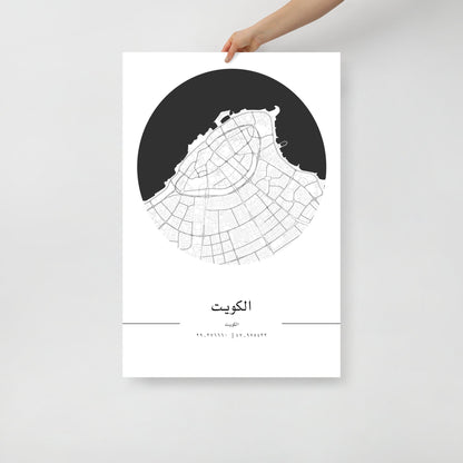 A hand holding a black and white map poster of Kuwait City.