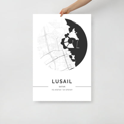 A black and white minimalist map poster of Lusail City, Qatar, held by a hand against a white background.