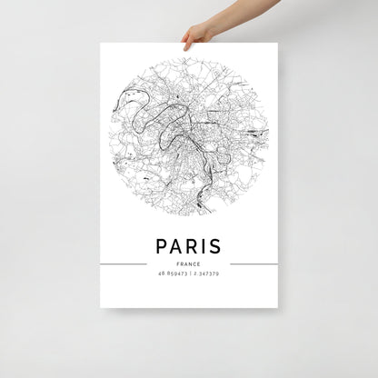 A person's hand holds an FN Prints Paris Map poster, printed on premium-grade paper. This black and white wall art showcases intricate street details, with the coordinates "48.856973 | 2.341379" elegantly displayed below.