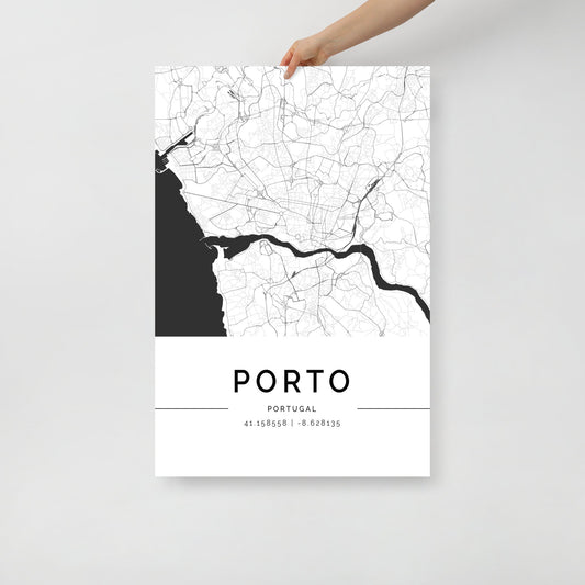 A hand displays a striking FN Prints creation, the Porto City Map, a black and white map poster that beautifully captures the urban charm of Porto, Portugal. The intricate street and river lines are prominent against the white backdrop, with "PORTO, PORTUGAL" and coordinates "41.158558 | -8.628135" elegantly featured at the bottom.