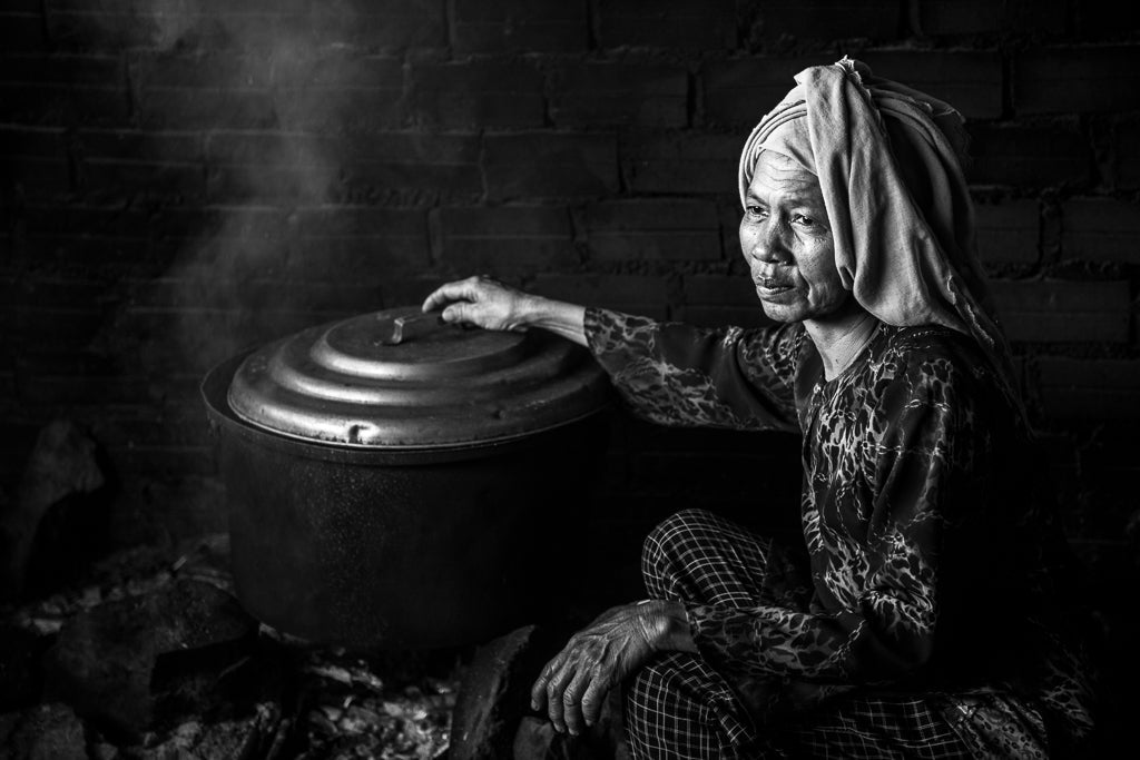 A woman with a cooking pot in Cambodia cooking crab. 