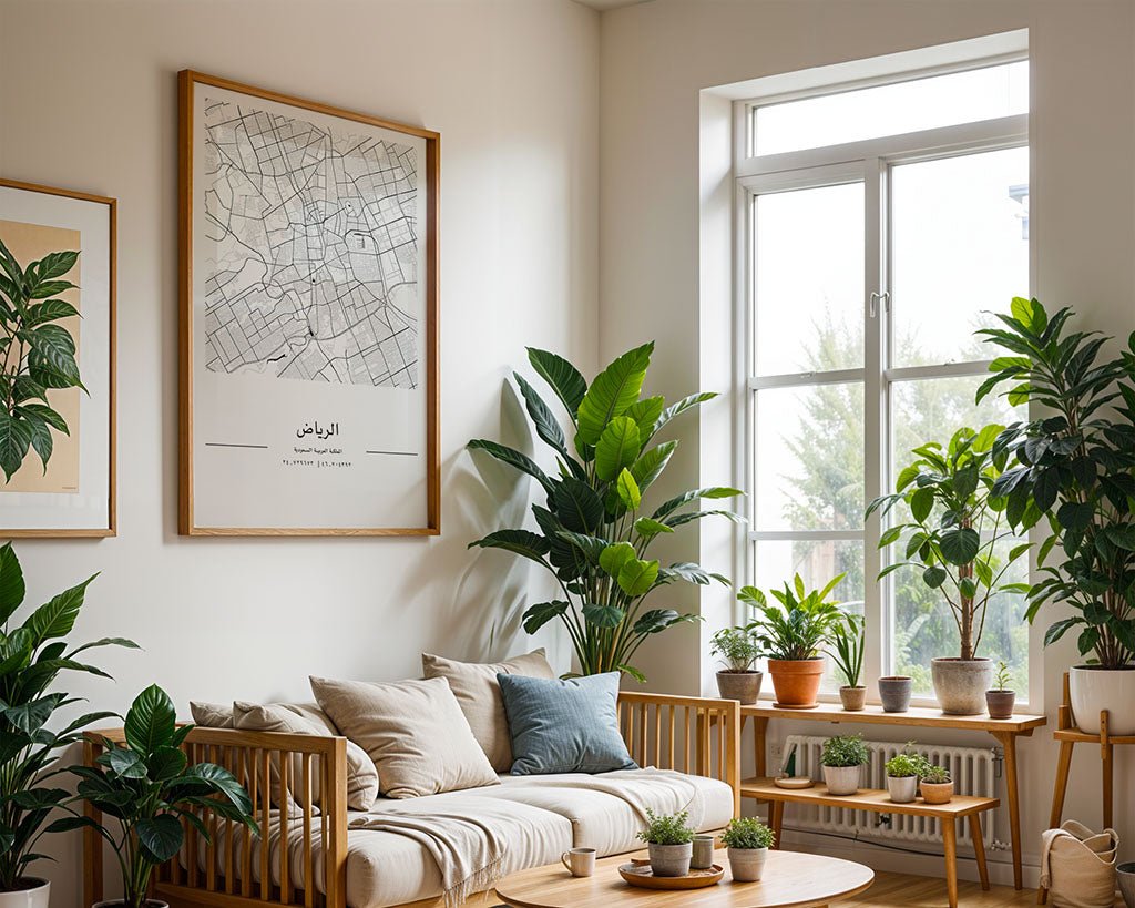 A bright living room with a wooden sofa, beige cushions, potted plants, and large windows. Framed artwork, including the FN Prints Riyadh City Map and other wall art, adds character to the space.