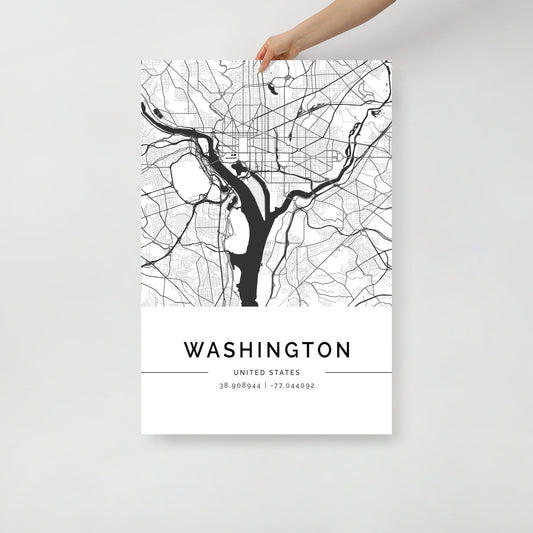 A person holds the FN Prints' Washington City Map, a minimalist black and white poster displaying roads and water bodies. The bottom of the map is adorned with coordinates, 38.904844, -77.046092, elegantly capturing the essence of this historic place with simplicity.