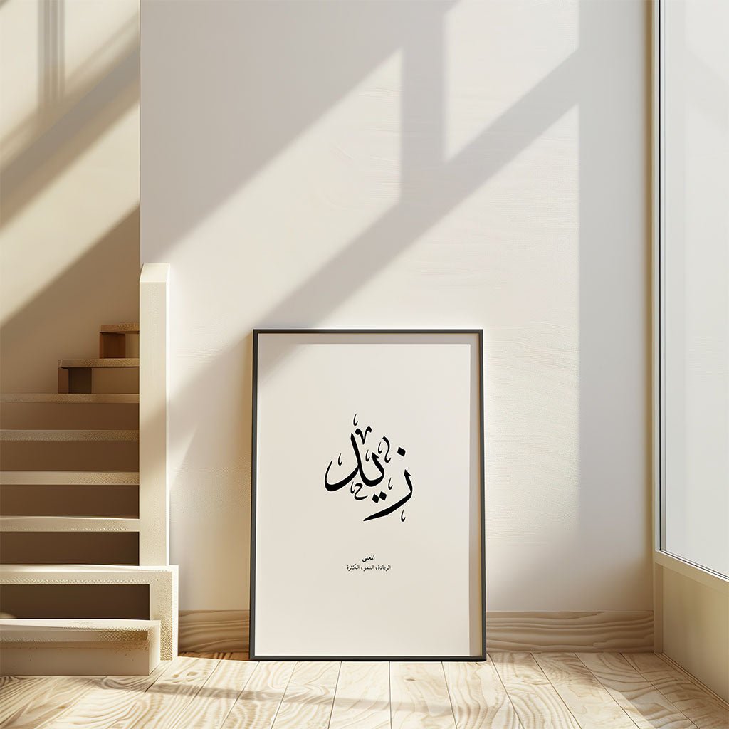 The FN Prints "Zaid - زيد" Arabic calligraphy artwork is framed and displayed against a white wall in a sunlit room, with light wooden stairs nearby—creating a calm space ideal for showcasing Islamic wall art.